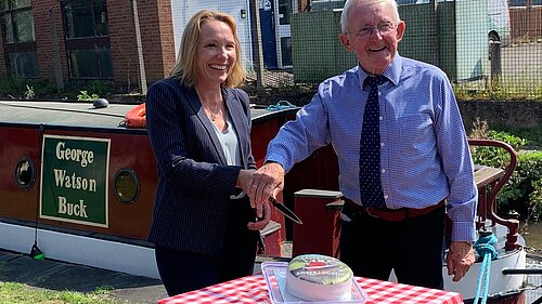 Helen helps cut the cake to celebrate