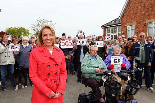 Helen Morgan with dozens of protesters outside the closed GP practice in St. Martins